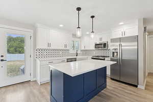 Kitchen featuring stainless steel appliances, light wood-style flooring, white cabinetry, plenty of natural light, and recessed lighting