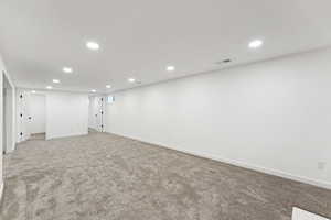 Finished basement featuring recessed lighting and light carpet