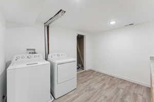 Laundry room with independent washer and dryer and light wood finished floors