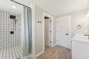 Full bath with a shower stall, wood finished floors, double vanity, and recessed lighting