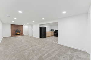 Unfurnished living room featuring light colored carpet, recessed lighting, and a fireplace