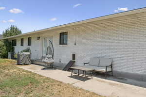 Rear view of house with a patio area and brick siding