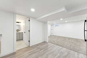 Below grade area featuring recessed lighting and light wood-style floors