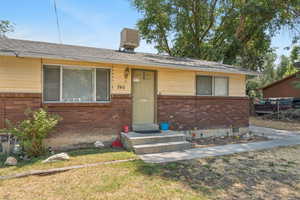 View of front of home featuring brick siding and a shingled roof