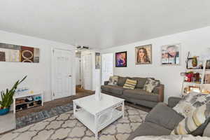 Living room with a textured ceiling and carpet floors