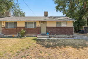 Ranch-style home with brick siding, a front lawn, and a shingled roof