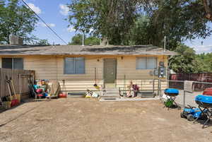 Rear view of property featuring entry steps and a fenced backyard