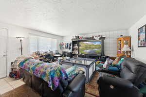 Living area with a textured ceiling and tile patterned floors
