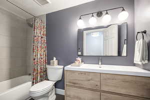 Bathroom featuring shower / bathtub combination with curtain and vanity