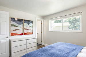Bedroom featuring dark wood-style flooring and baseboards