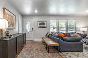 Living room with a textured ceiling and wood finished floors
