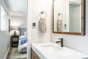 Ensuite bathroom with vanity and dark wood-style floors