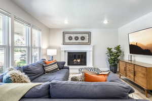 Living room with a glass covered fireplace, wood finished floors, and a textured ceiling