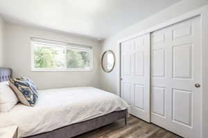 Bedroom with wood finished floors and a closet