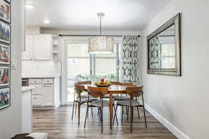 Dining room with light wood finished floors and recessed lighting