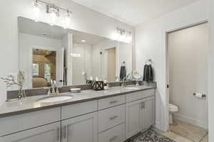 Bathroom featuring double vanity, ensuite bathroom, tile patterned flooring, and tiled shower