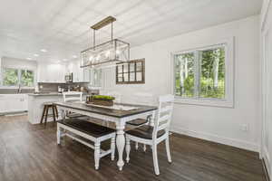 Dining space with dark wood-style floors, a chandelier, and recessed lighting