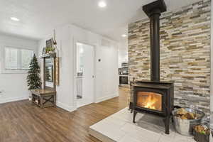 Living area featuring a wood stove, wood finished floors, recessed lighting, and a textured ceiling