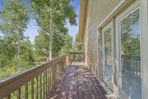 Wooden terrace featuring view of wooded area