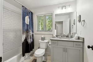 Full bathroom featuring vanity, shower / bathtub combination with curtain, tile patterned floors, and a textured ceiling