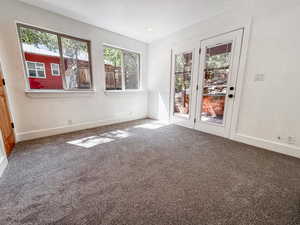 Carpeted spare room featuring baseboards