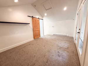 Empty room with lofted ceiling, carpet flooring, a baseboard heating unit, a barn door, and recessed lighting