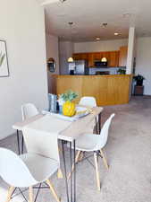 Dining space featuring light carpet and baseboards