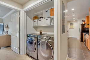 Laundry room with washer and dryer, recessed lighting, tile patterned flooring, and crown molding