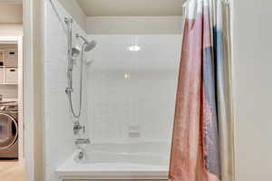 Full bath with washer / dryer and shower / bathtub combination with curtain