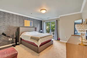 Carpeted bedroom featuring ornamental molding, wallpapered walls, and access to outside