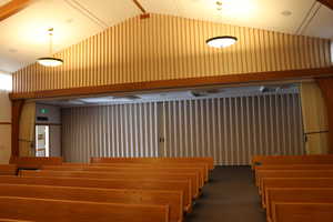 View of chapel with accordion wall at the rear, separating pews from additional space for seating