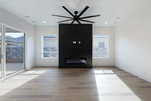 Unfurnished living room with light wood finished floors, recessed lighting, and a ceiling fan