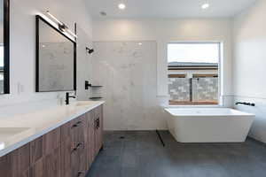 Bathroom featuring double vanity, a freestanding bath, tile walls, recessed lighting, and a tile shower