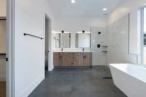 Full bath featuring double vanity, a freestanding bath, recessed lighting, and a shower