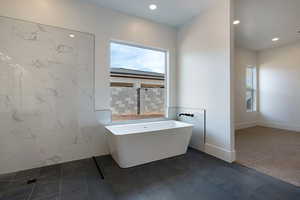 Full bathroom featuring plenty of natural light, a soaking tub, and recessed lighting