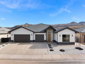 Modern farmhouse style home featuring board and batten siding, an attached garage, a mountain view, and driveway