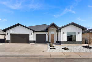 Modern inspired farmhouse with board and batten siding, a garage, stone siding, a tiled roof, and driveway