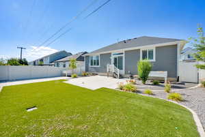 Rear view of house with a patio and artificial tuff.