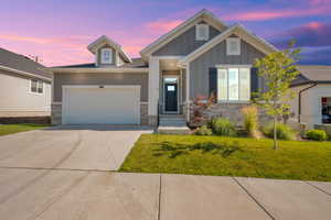 Craftsman-style house featuring concrete driveway, an attached garage, with board and batten siding