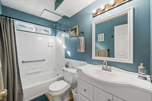 Bathroom featuring shower / bath combo, a wainscoted wall, and vanity