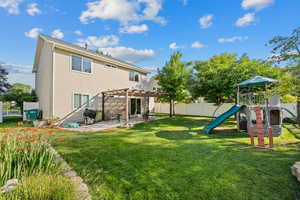 Back of property featuring a pergola, a patio area, and a playground
