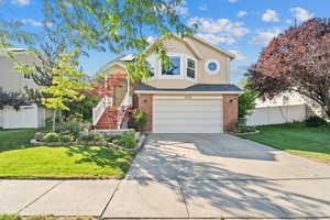 View of front of property featuring a garage, driveway, and stucco siding