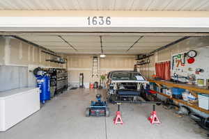 Garage with refrigerator and a workshop area