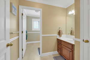 Bathroom featuring crown molding and vanity