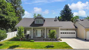 Cape cod house with an attached garage, concrete driveway, covered porch, roof with shingles, and a chimney
