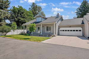 View of front of house featuring a garage, concrete driveway, a shingled roof, and a chimney
