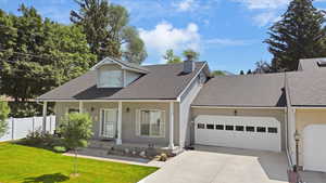 View of front of house featuring a garage, a porch, concrete driveway, roof with shingles, and a chimney