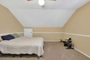 Bedroom featuring vaulted ceiling, carpet, and ceiling fan