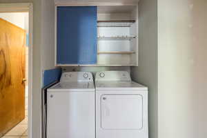 Washroom featuring washing machine and dryer and light tile patterned floors
