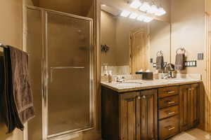 Full bath featuring a stall shower and double vanity
